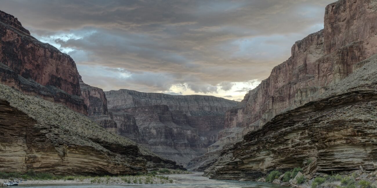 Colorado River flowing through the inner Grand Canyon beneath stormy blue clouds