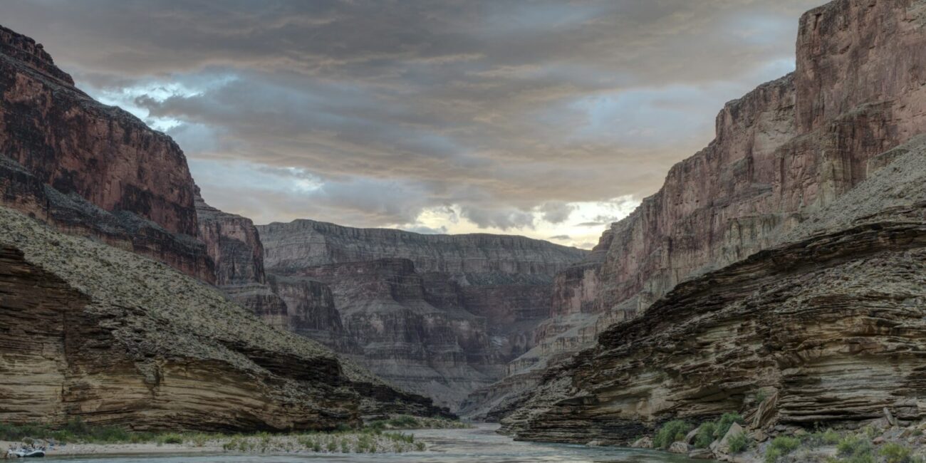 Colorado River flowing through the inner Grand Canyon beneath stormy clouds