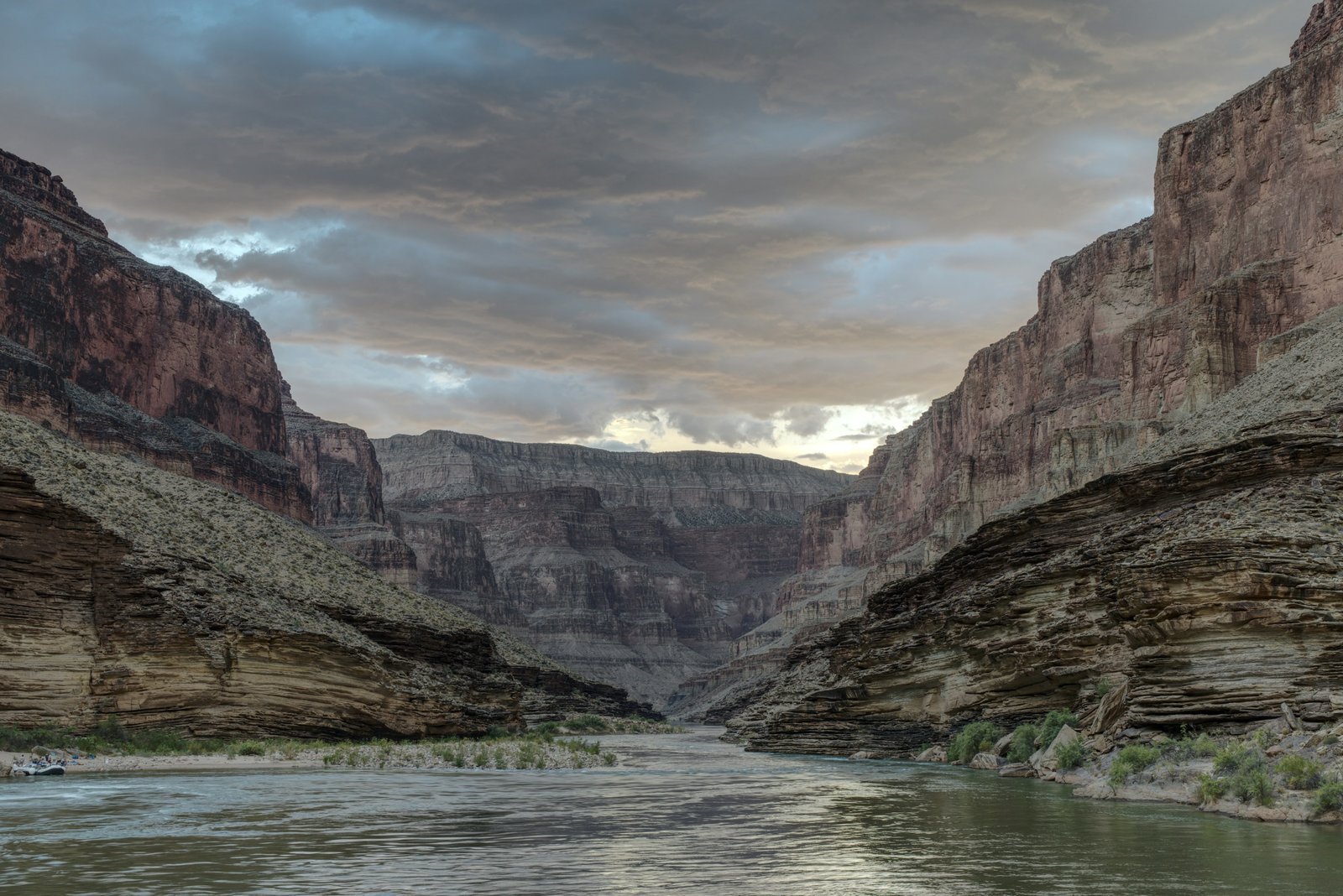Colorado River flowing through the inner Grand Canyon beneath stormy blue clouds