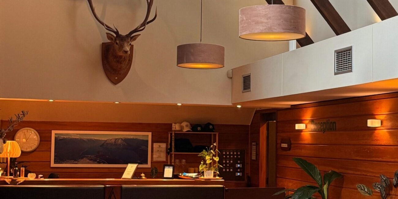 Warm lodge interior with rustic wood details, seating, and front desk