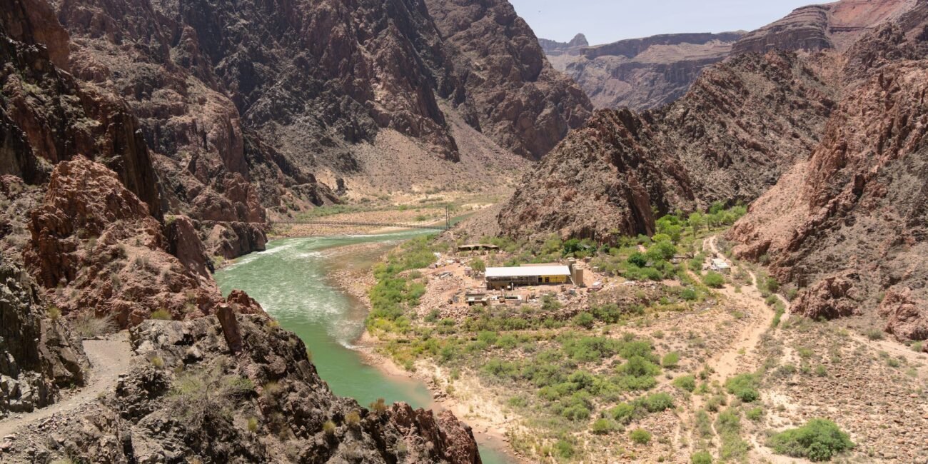 Colorado River winding below rugged Grand Canyon walls and hiking terrain