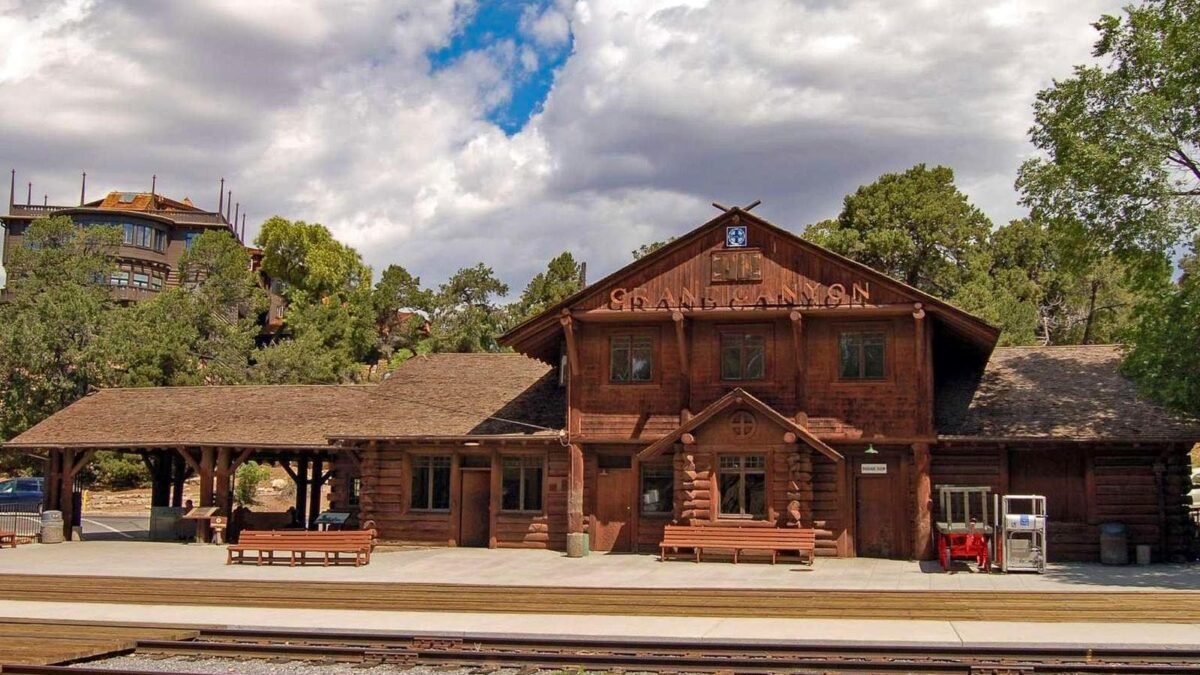 Historic Grand Canyon Railway Depot in Grand Canyon Village with railroad tracks in front