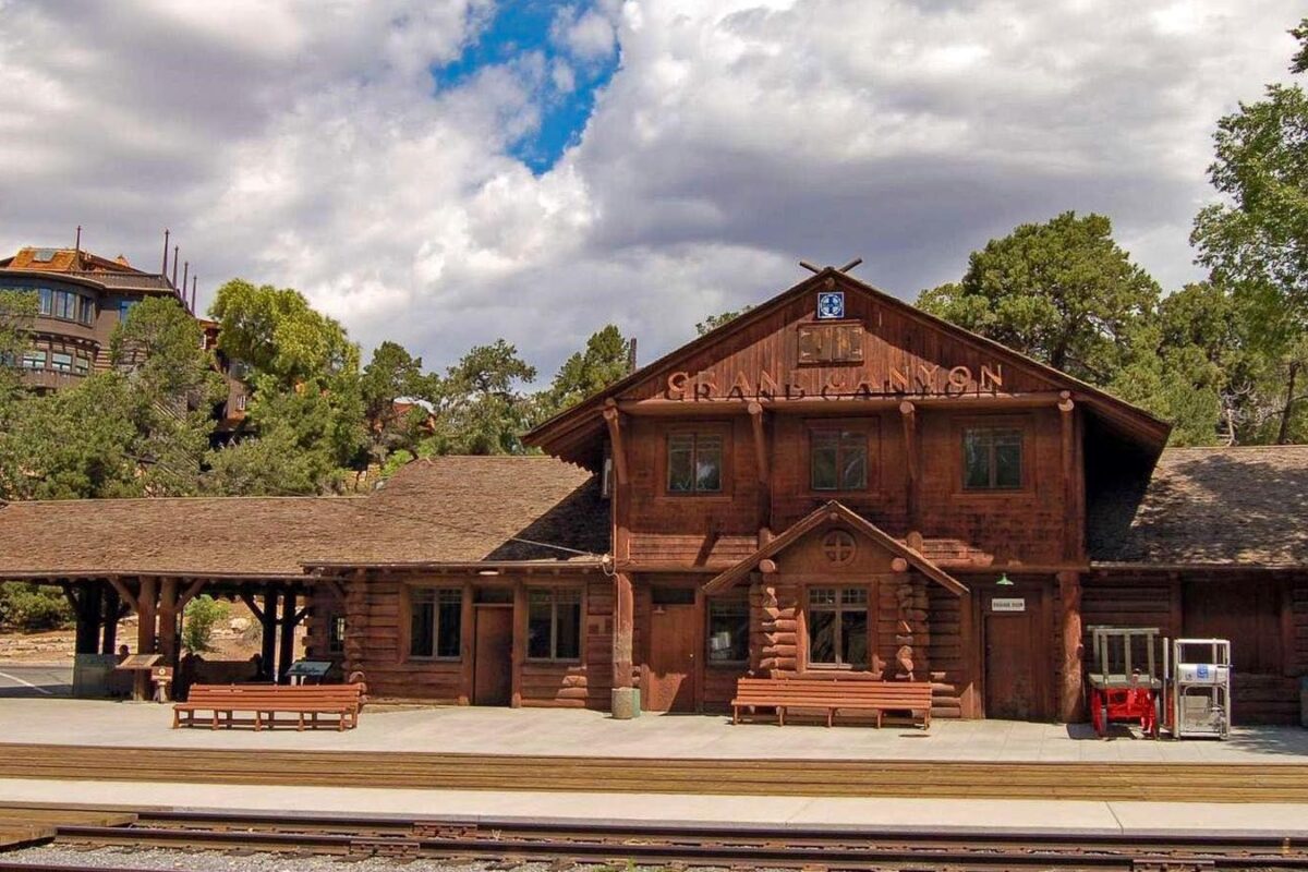 Historic Grand Canyon Railway Depot in Grand Canyon Village with railroad tracks in front