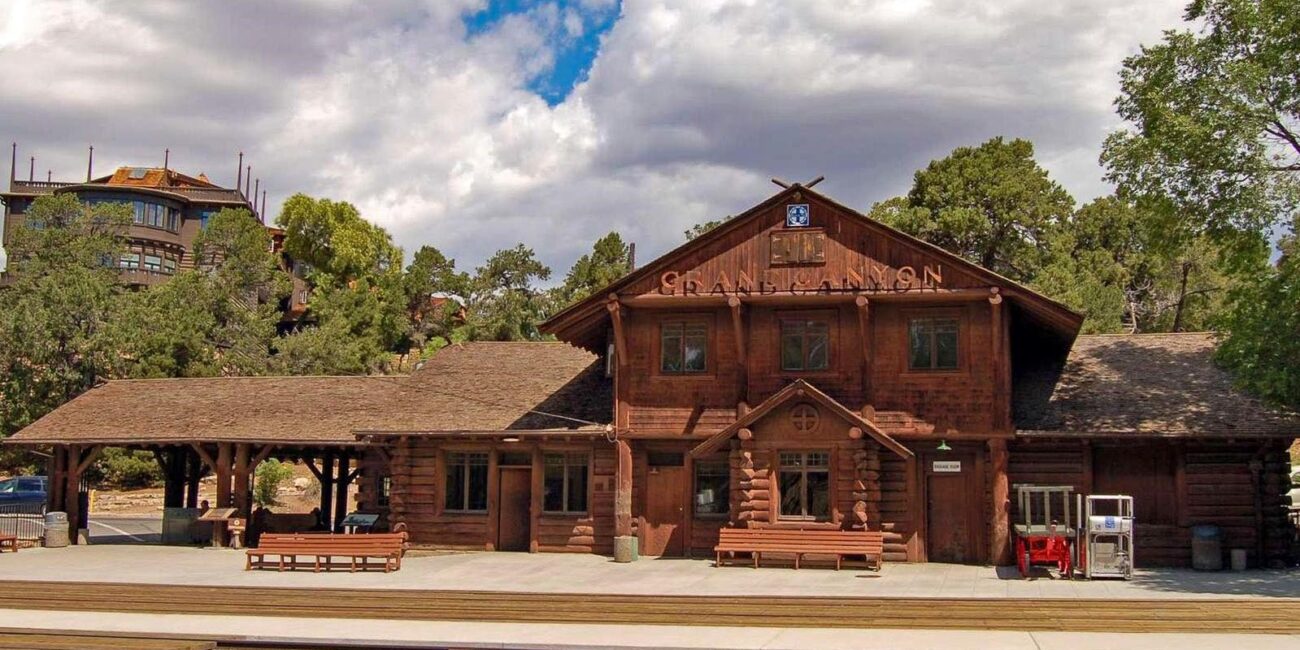 Historic Grand Canyon Railway Depot in Grand Canyon Village with railroad tracks in front