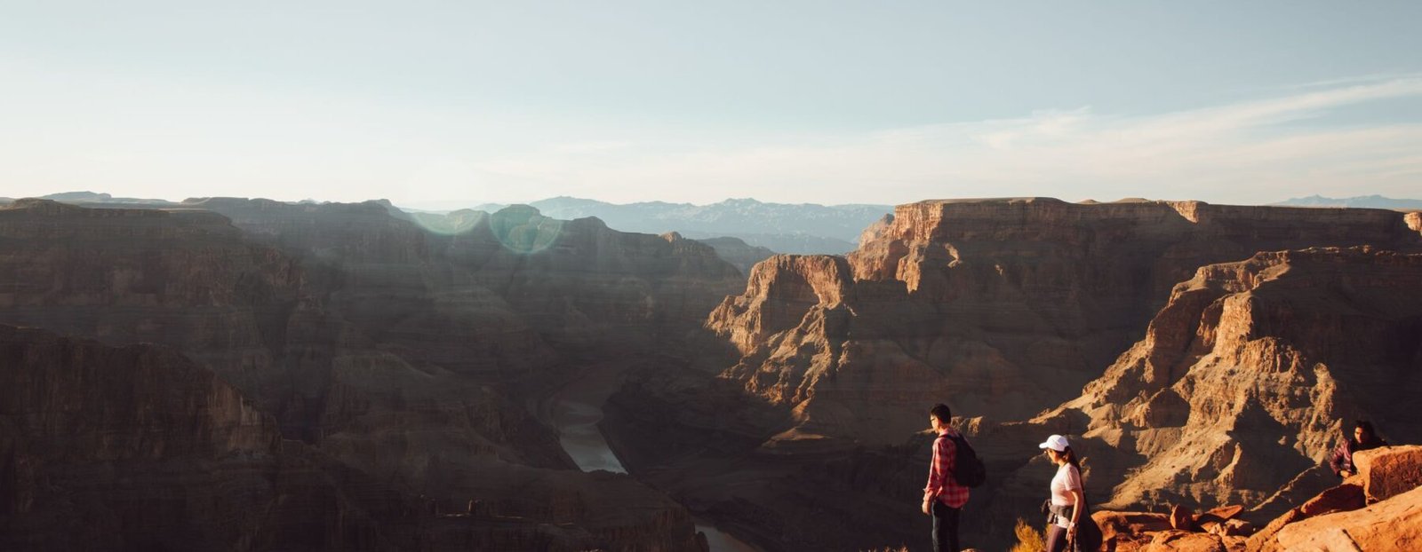 Visitors photographing the Grand Canyon in warm low-angle light