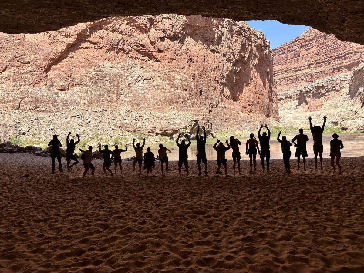 Group silhouetted inside the immense Redwall Cavern