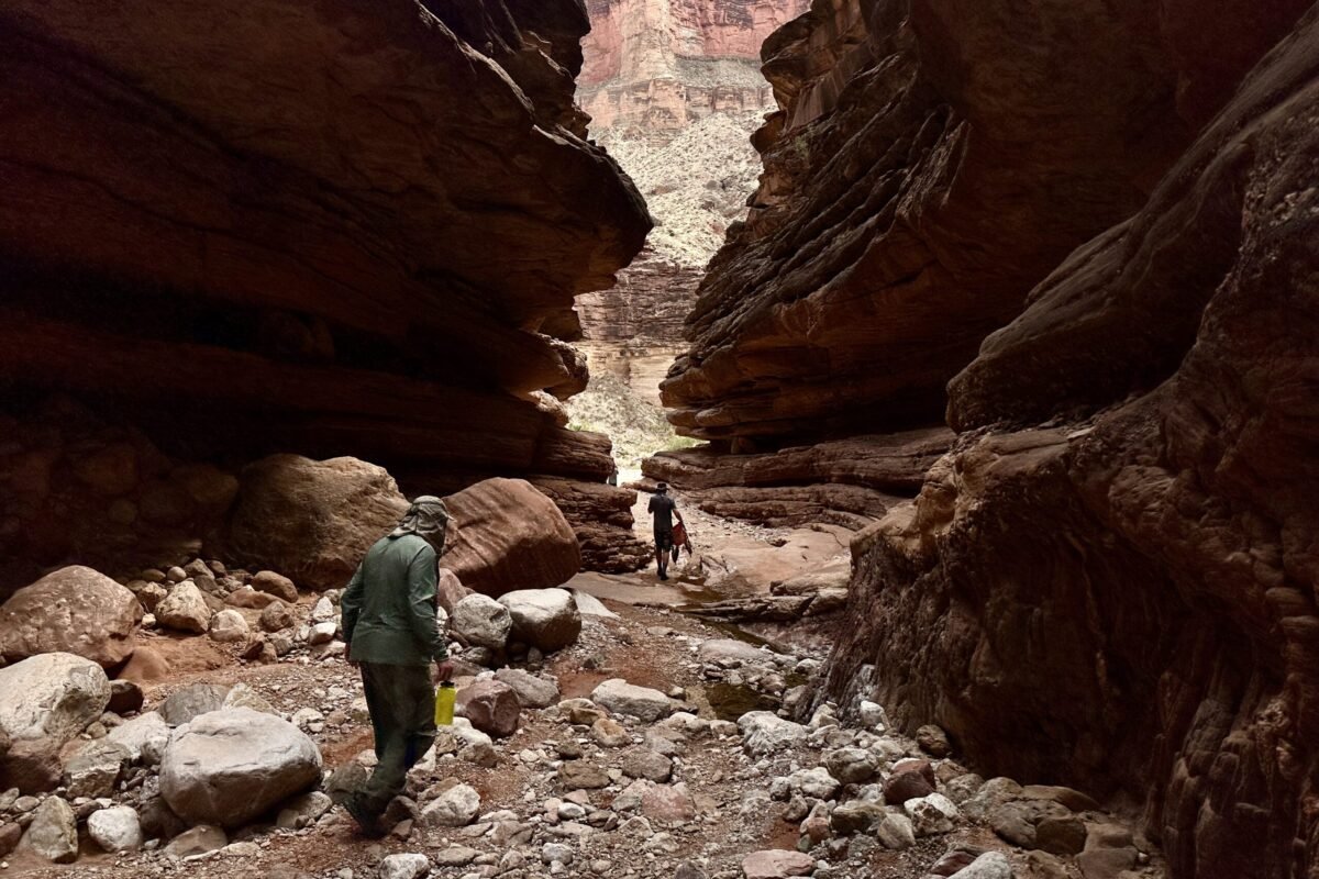 Hikers moving through a narrow rocky passage in the Grand Canyon