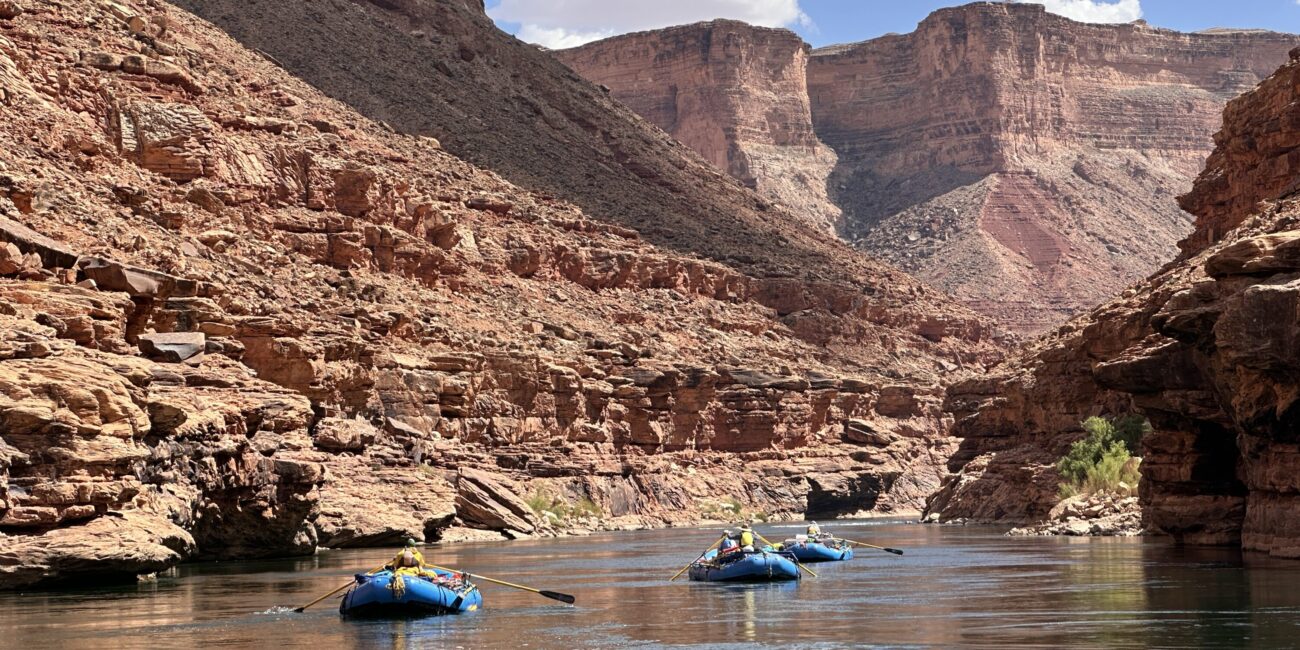 Rafts floating on calm water in the Grand Canyon